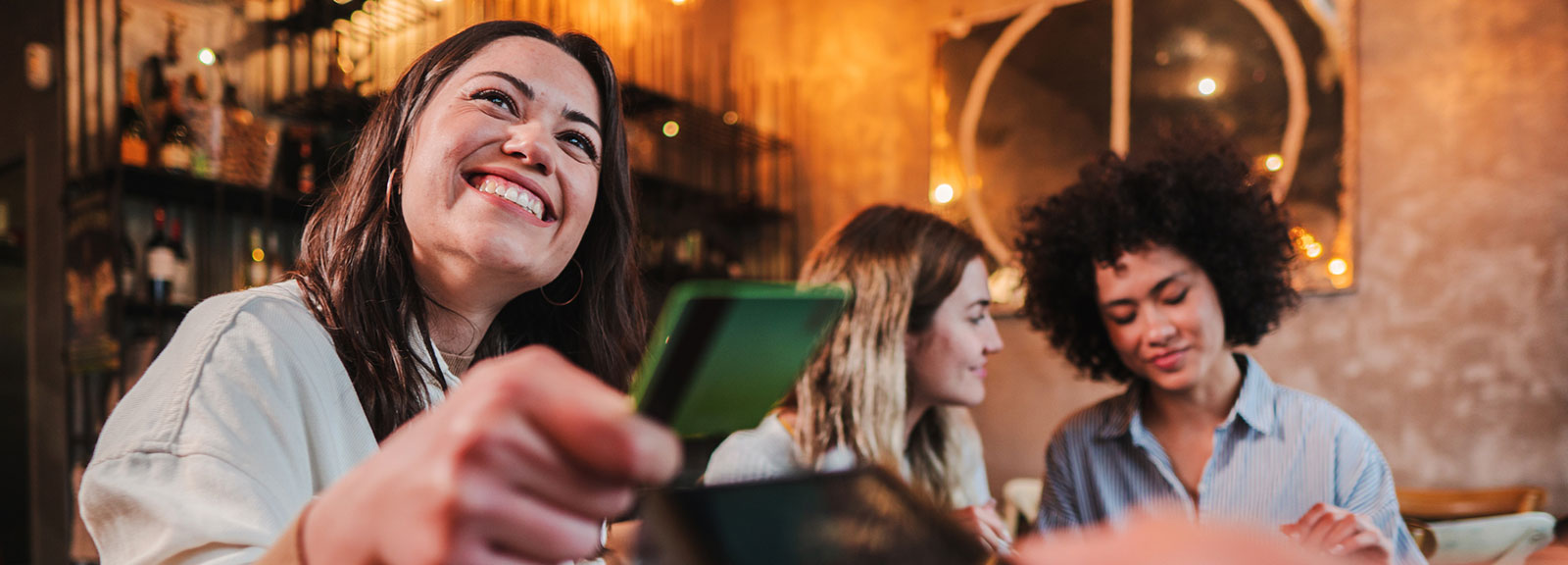 Woman paying for dinner with card at restaurant