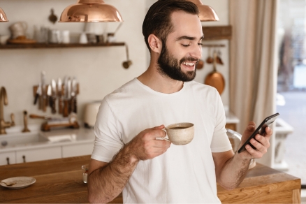 man in kitchen smiling at phone