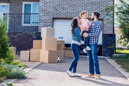 Family of 3 in front of new house