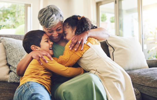 woman hugging two kids