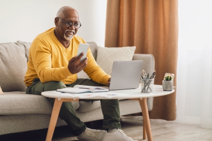 man in yellow sweater on computer