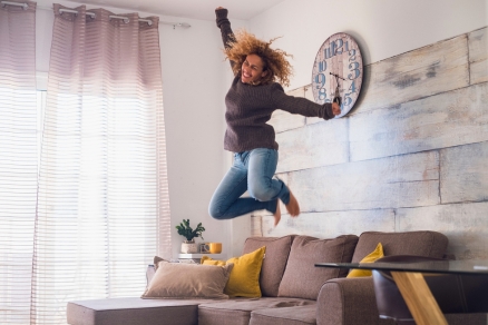 Woman jumping up in living room