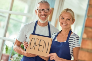 Couple holding open sign
